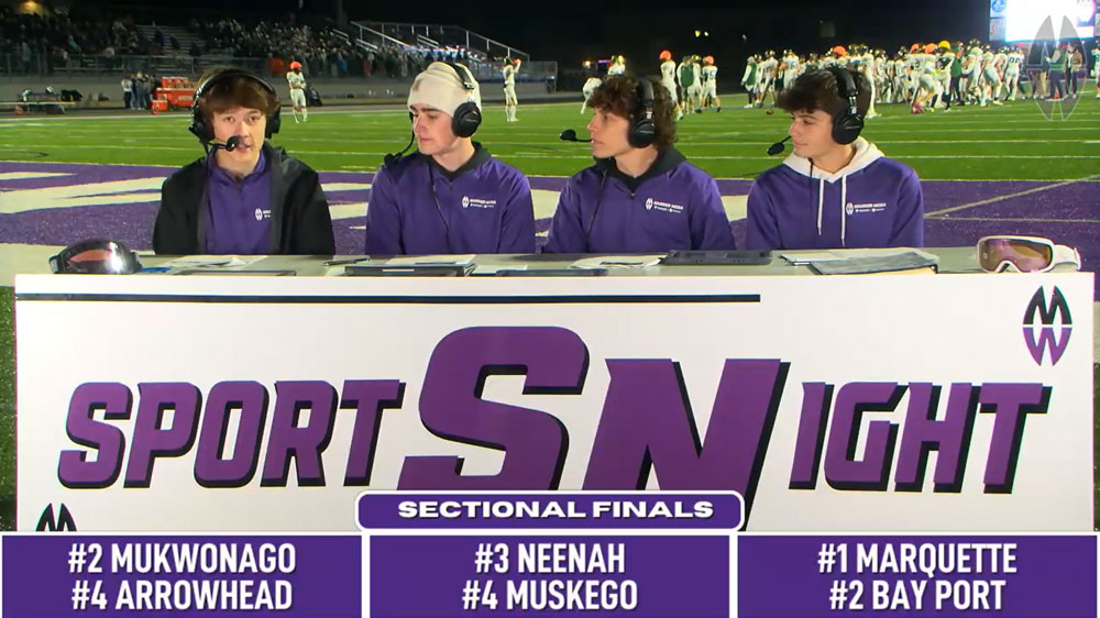 students at sports broadcast table