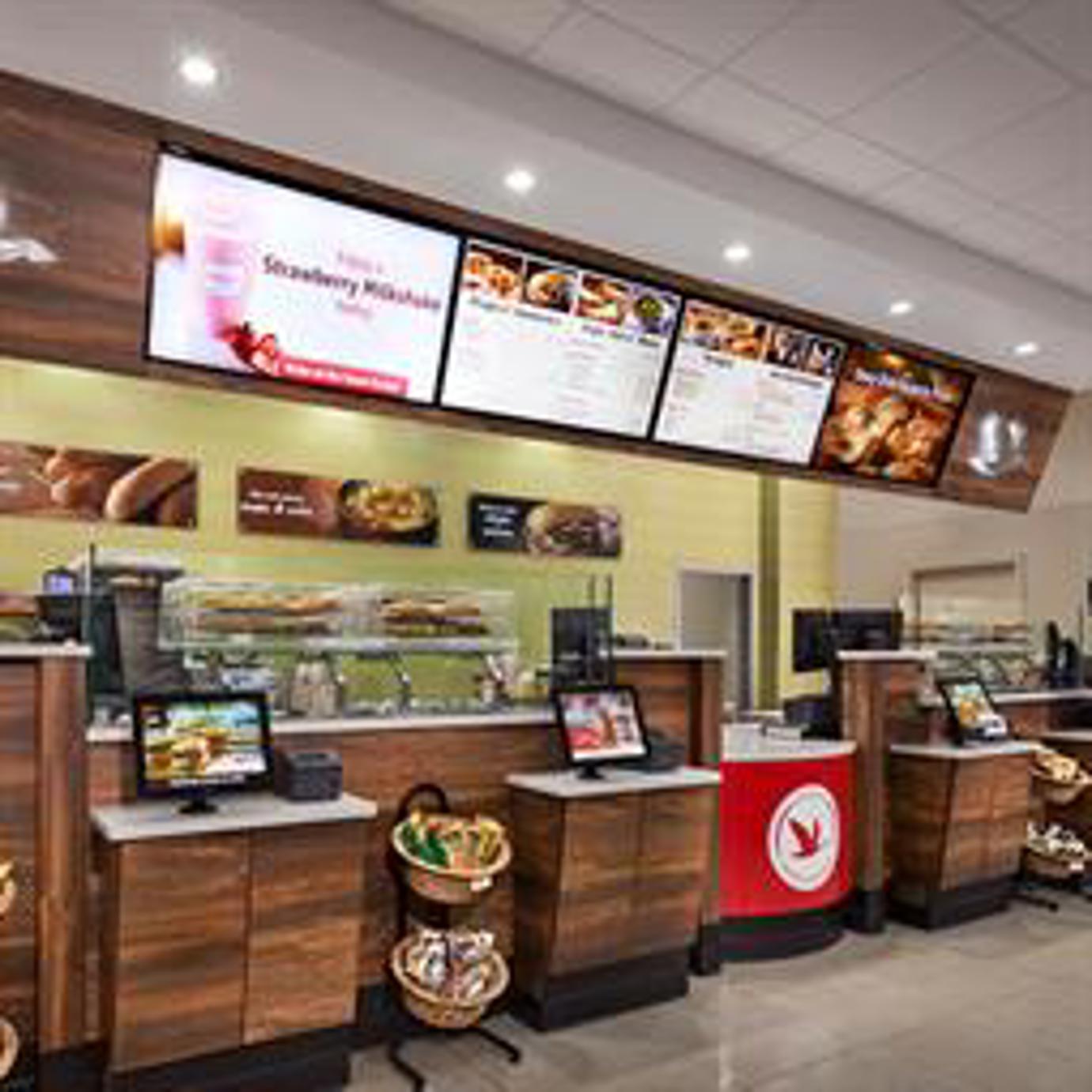LCD menu boards behind checkout counter