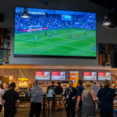 large LED screen in concourse above digital menu boards